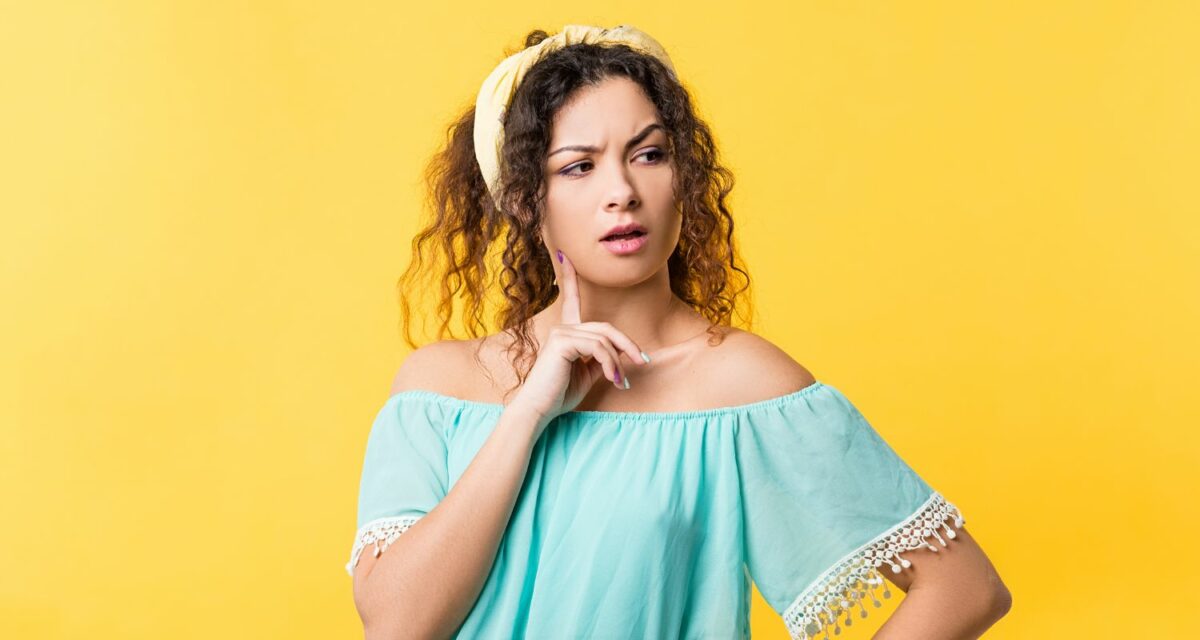 Young deaf woman with serious look on her face on yellow background