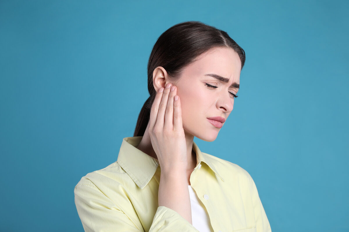 Young woman holding her hand to her ear