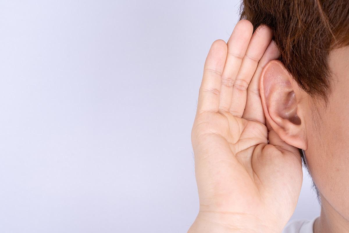 Man cupping his hand behind his ear