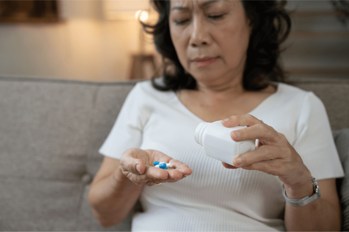 Woman dumping pills out of a bottle into her hand